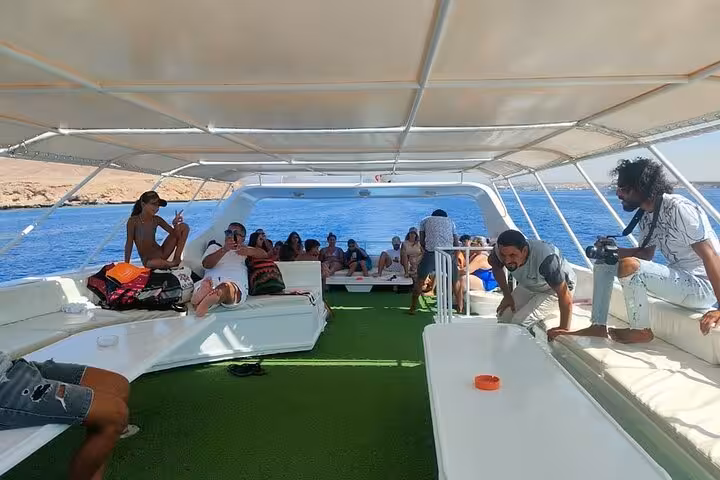 Guests relax on a shaded boat deck during Ras Mohammed and White Island snorkeling trip from Sharm El Sheikh