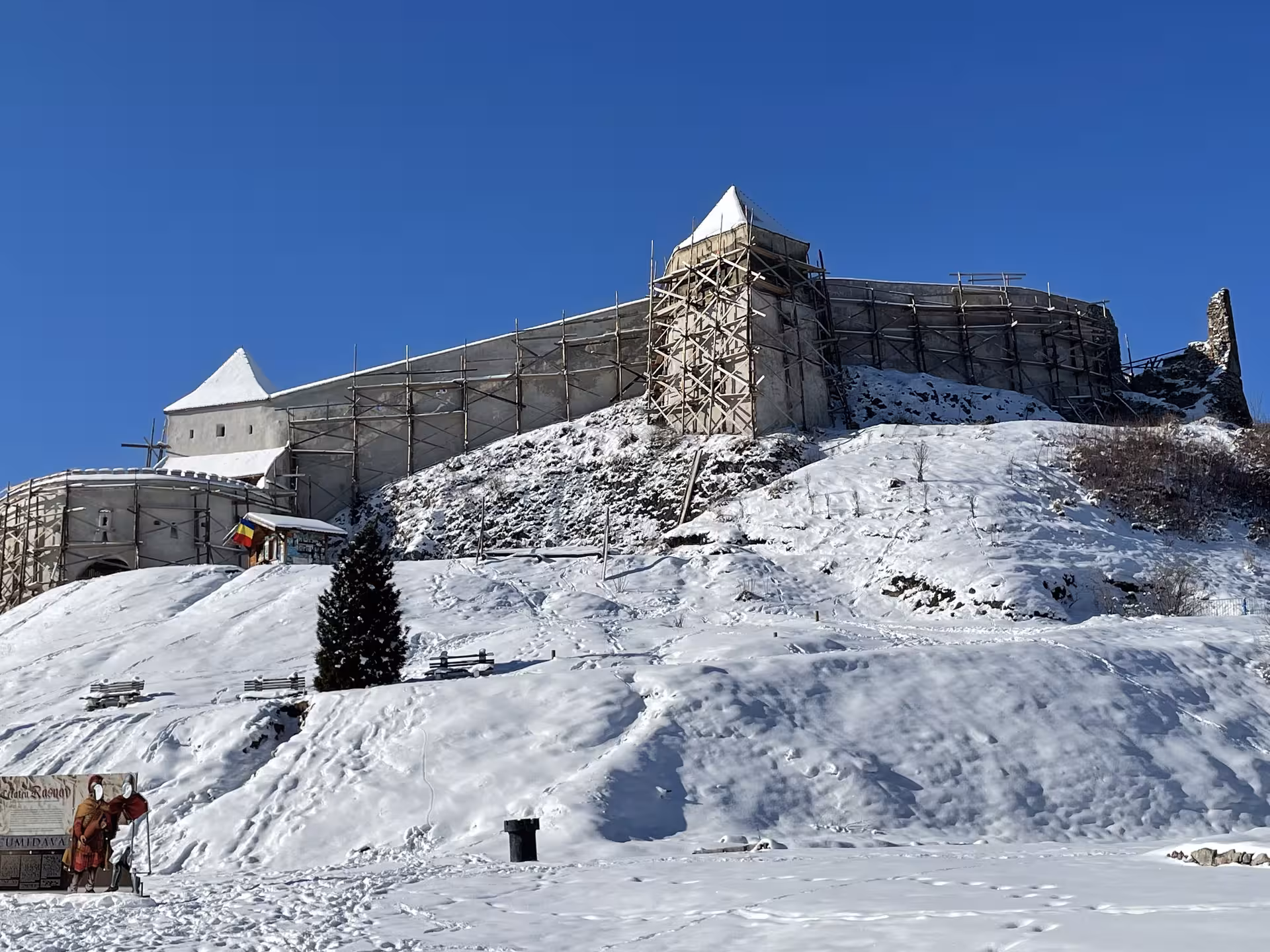 Rasnov Fortress covered in snow with scaffolding during winter restoration, Brasov Romania