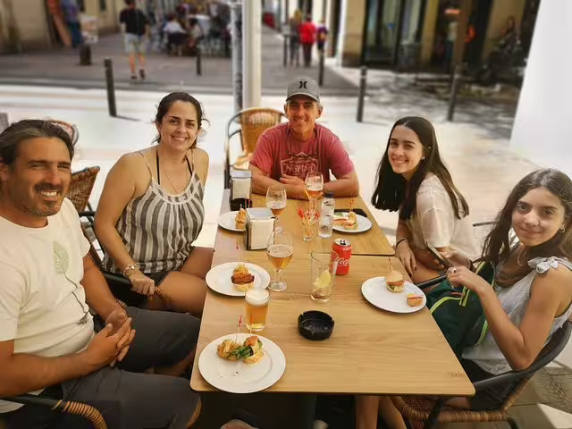 Group enjoying tapas at an outdoor cafe in Raval Quarter, Barcelona, during a private walking tour experience.