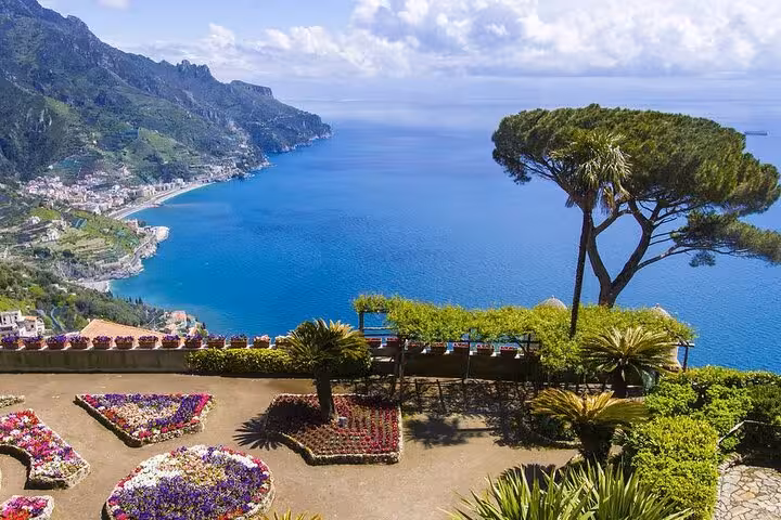 Panoramic view of lush gardens and blue coastline from Ravello, highlighting the beauty of Amalfi Coast tours.