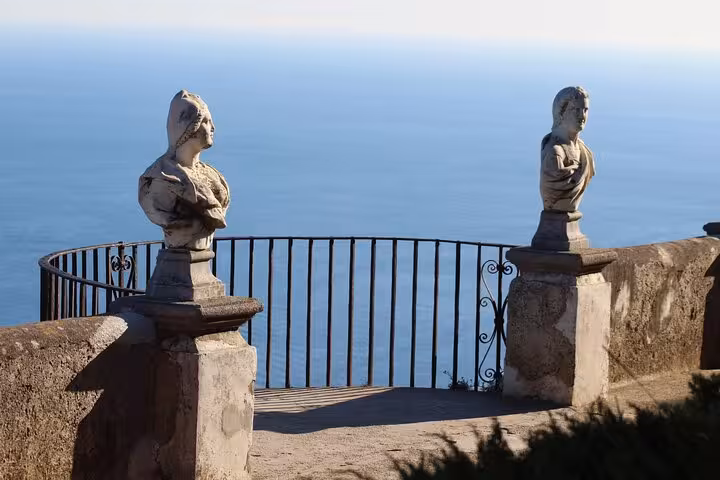 Close-up of stone busts on a terrace with panoramic sea views in Ravello, Amalfi Coast tour.