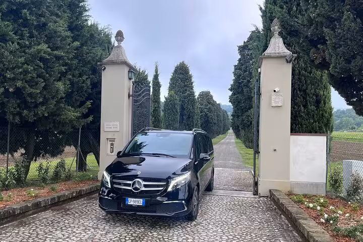 Luxurious hotel entrance with Mercedes van ready for seamless cruise terminal to Bologna airport transport.