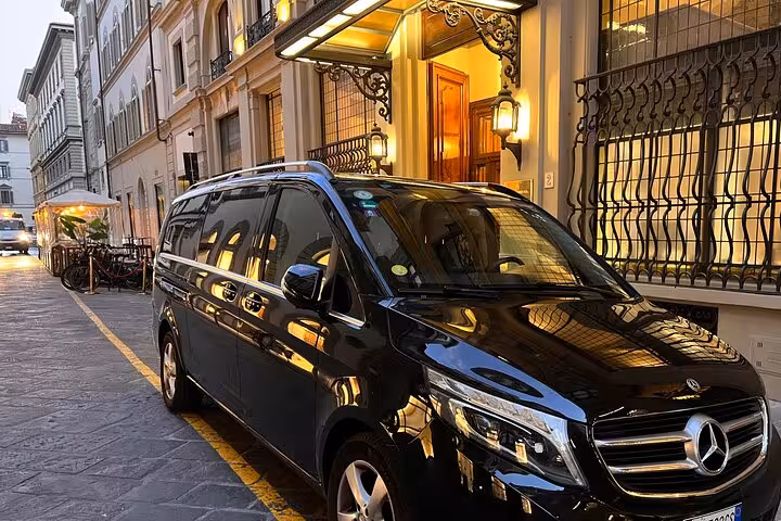 Luxury black Mercedes van parked outside a historic building in Ravenna for transfer to Bologna Airport.