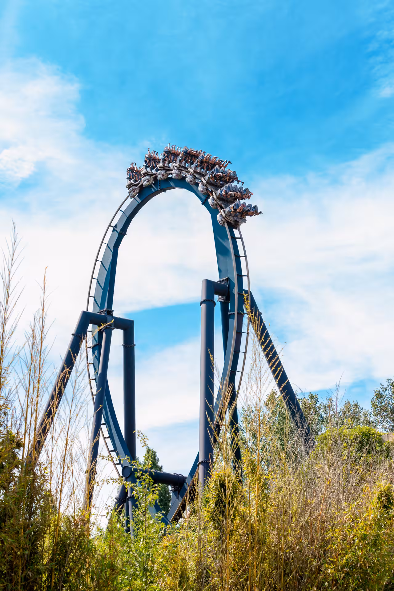 Mirabilandia roller coaster loop in Ravenna, Italy, with riders upside down on thrilling ride under blue sky
