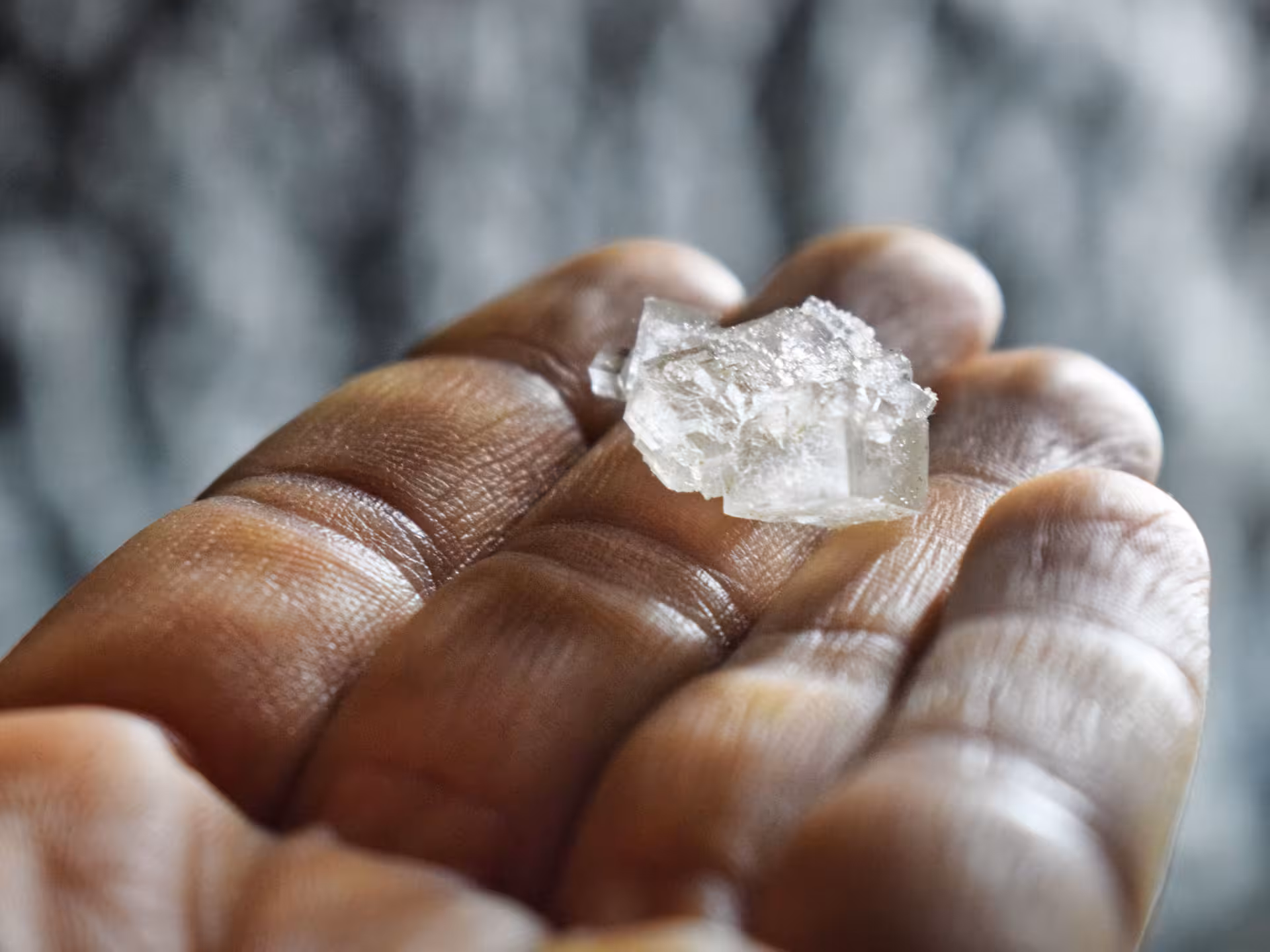 A raw salt crystal held in hand, showcasing natural minerals found during Turda Salt Mine full-day tour in Romania.