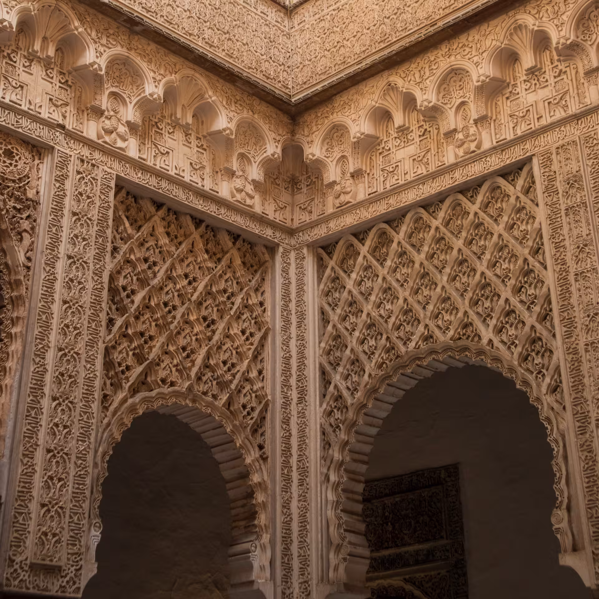 Detailed Islamic geometric patterns and carvings adorn the walls of the Real Alcázar of Seville's interior.