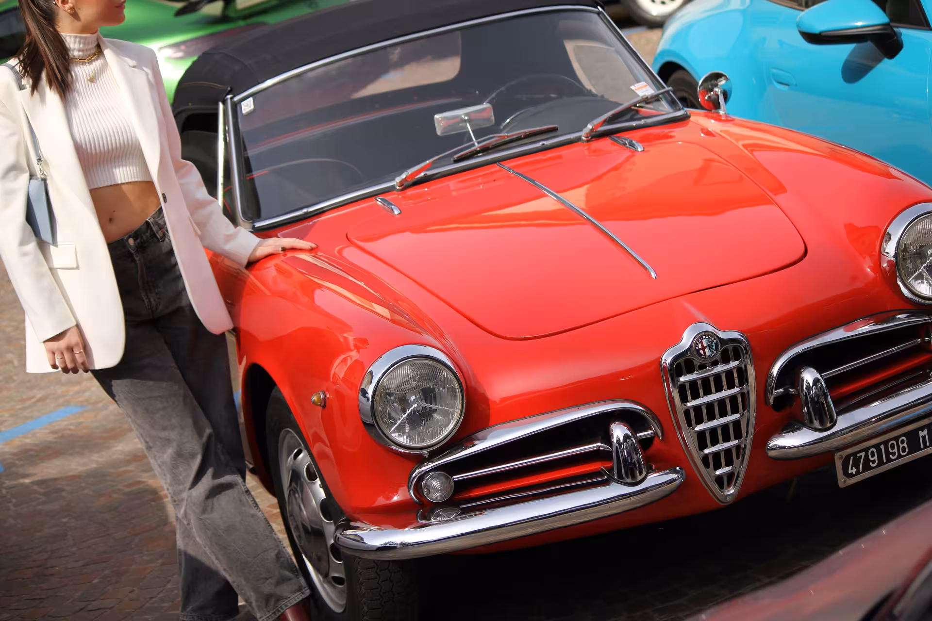 Woman in white blazer beside a classic red Alfa Romeo convertible at Lake Como vintage car tour