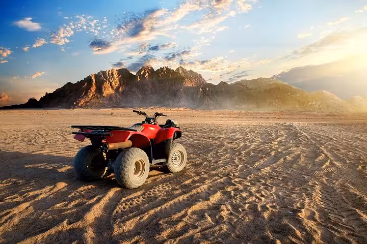 Red ATV quad bike on Hurghada desert safari at sunset with mountains, part of 3-hour quad and camel ride