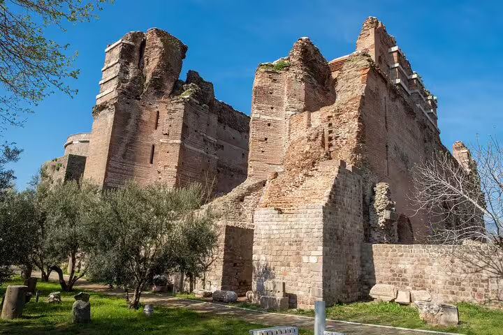 Marvel at the majestic ruins of the Red Basilica in Pergamon, surrounded by lush greenery and historical allure.