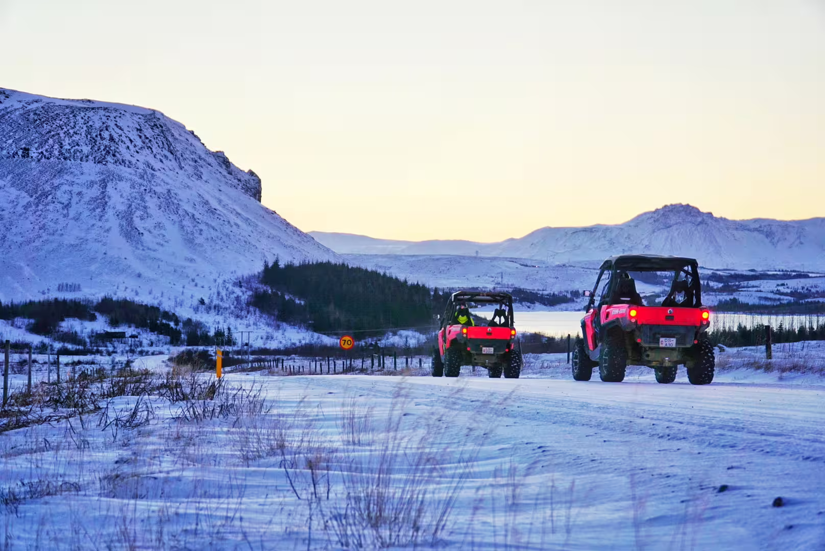Red buggies traverse snowy terrain with stunning mountain views during a thrilling 1-hour buggy safari adventure.
