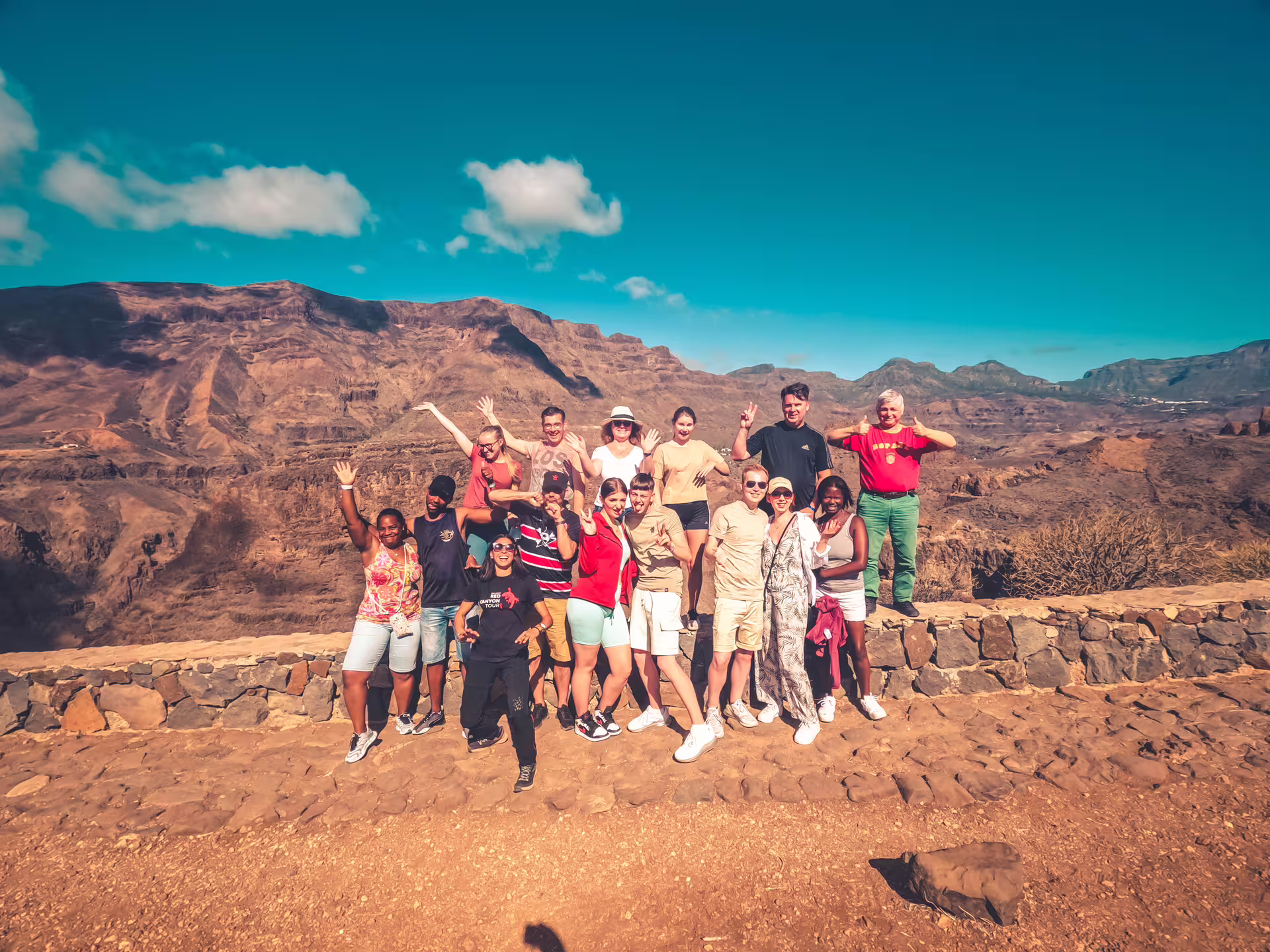 Group of tourists enjoying scenic views on the Red Canyon Tour under a clear blue sky.