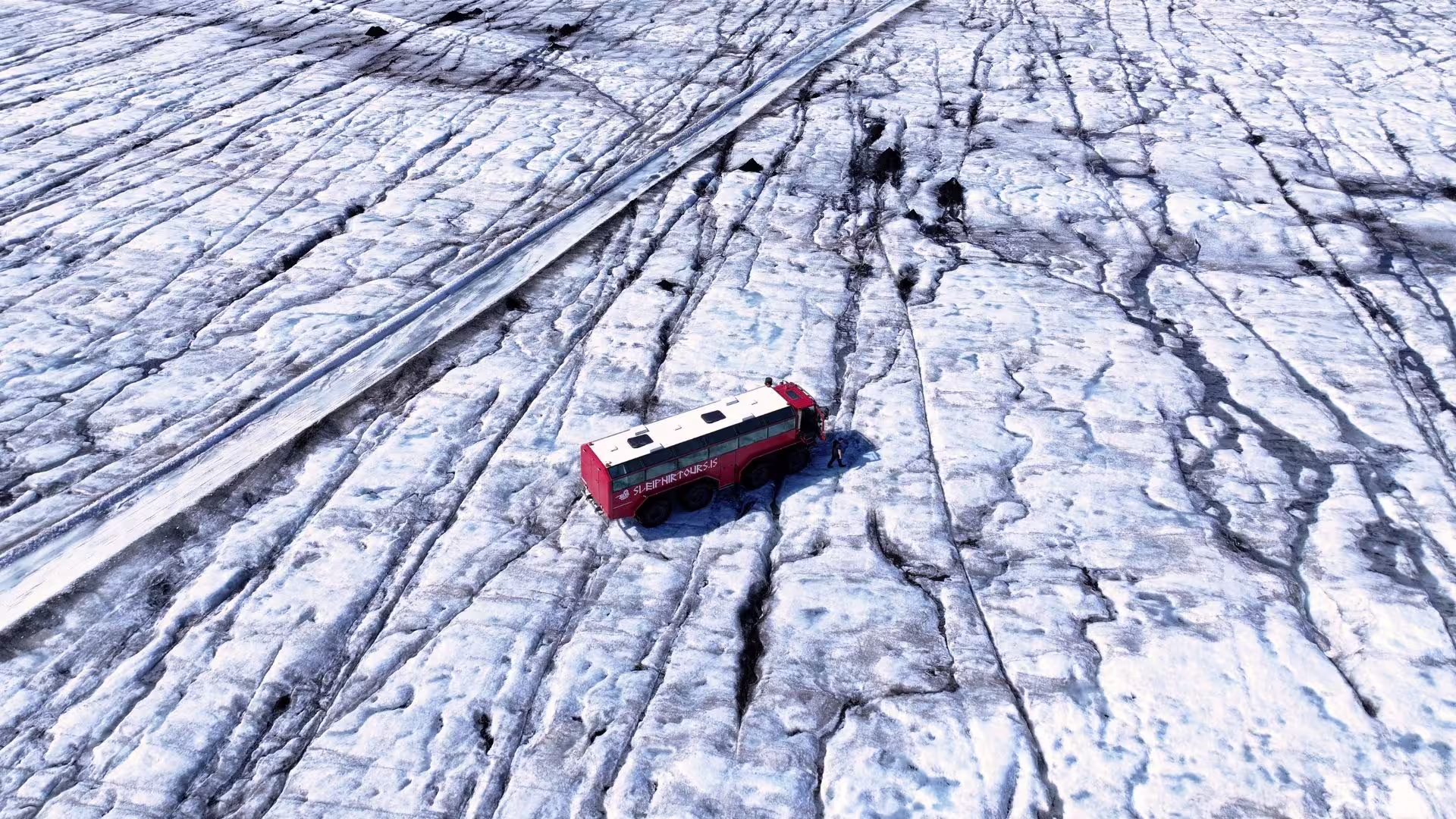 Red glacier bus on Langjökull ice cap during Summer Solstice tour from Gullfoss, Iceland glacier adventure