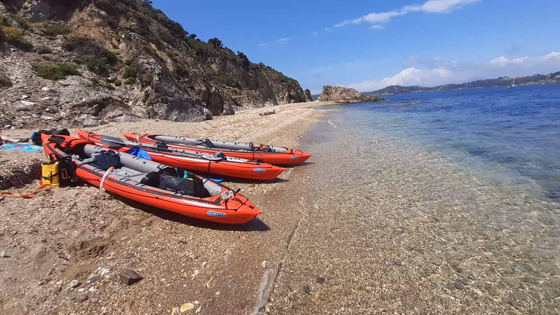 Kayaks rouges sur rive de galets et eau turquoise aux îles des Embiez, sortie kayak naturaliste Cap Sicié
