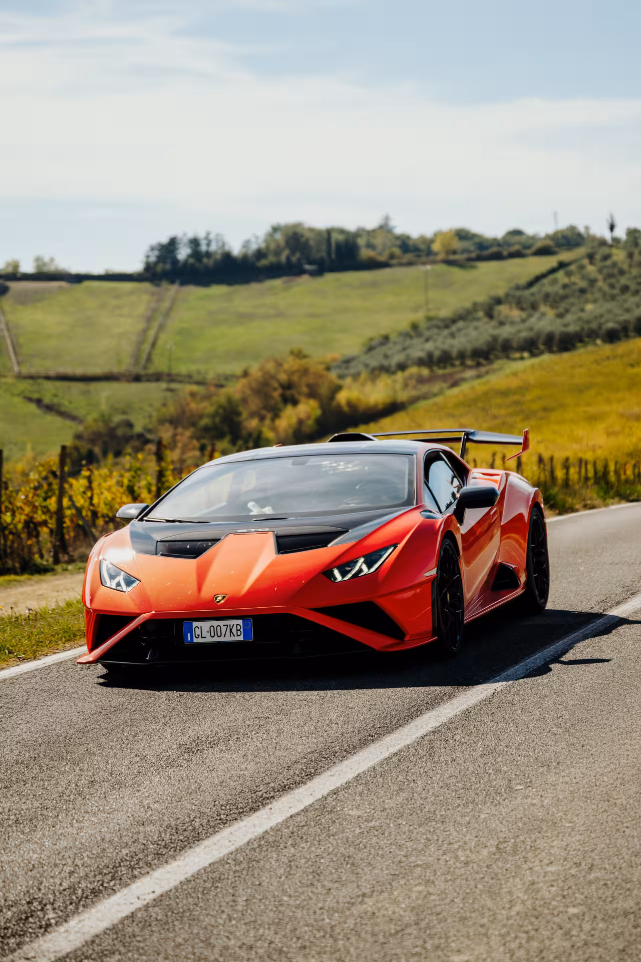 Red Lamborghini Huracán STO on a scenic Chianti countryside road in Siena, Tuscany