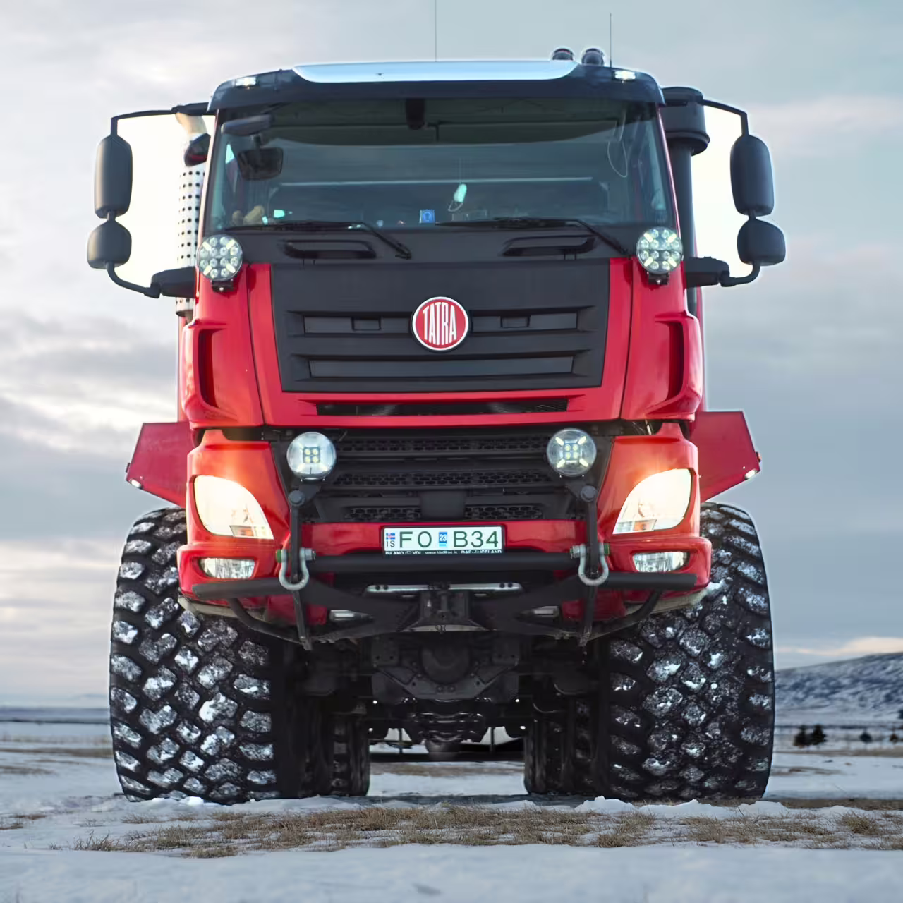Red monster truck on snowy Iceland track for Golden Circle and glacier adventure tour from Reykjavik