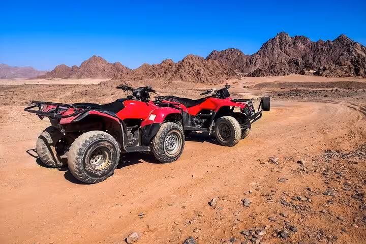 Two red quad bikes parked on Sinai desert track near Sharm El-Sheikh, ATV safari before stargazing and BBQ