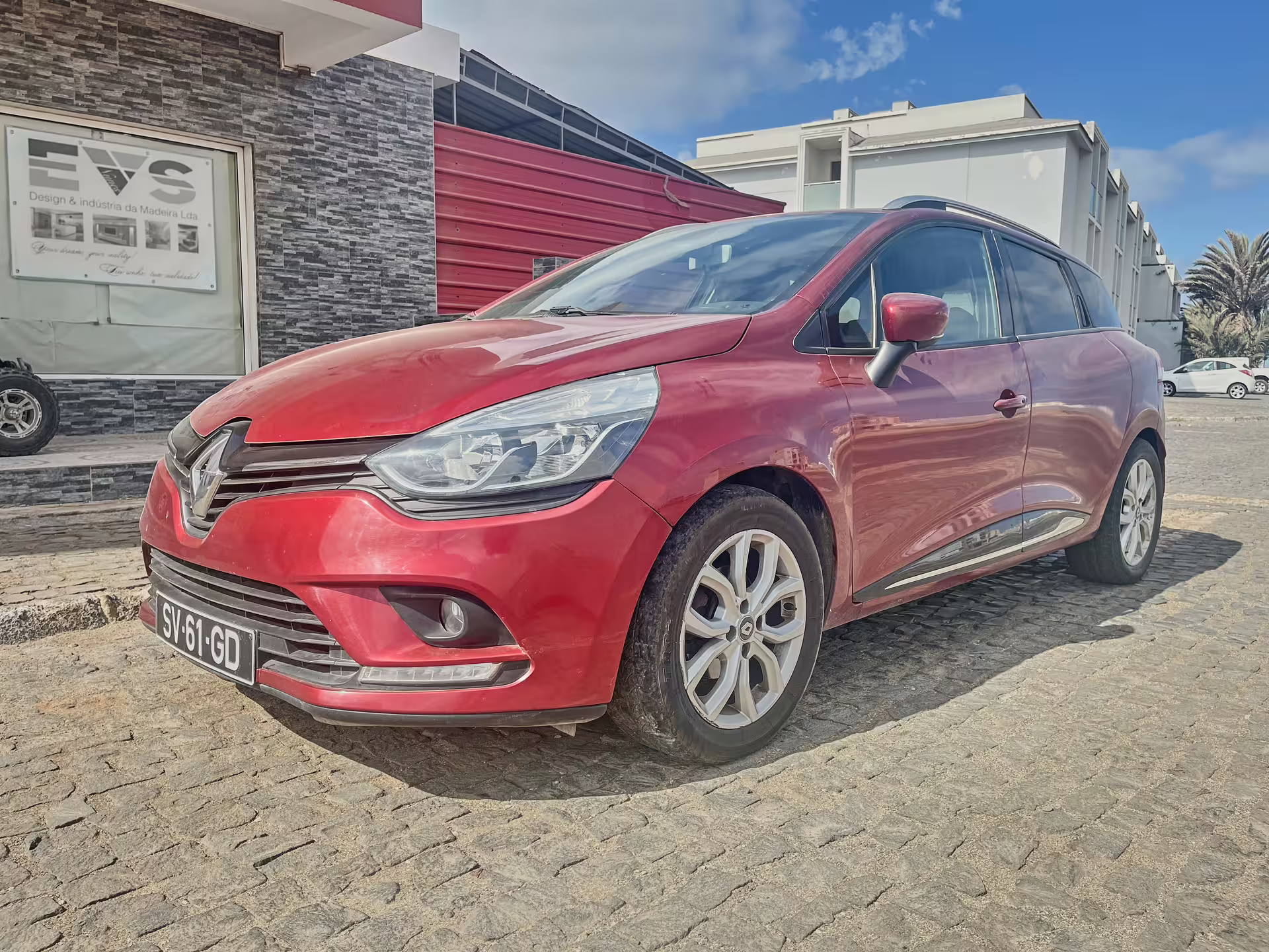 Red Renault estate car ready for private airport transfer, comfortable door-to-door shuttle on cobblestone street