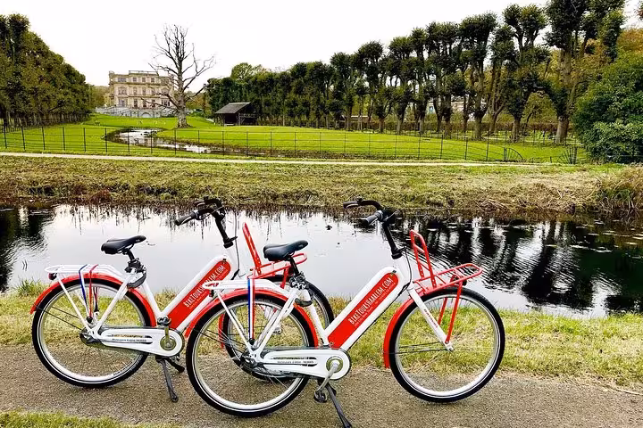 Red rental bikes by a canal near Haarlem estate gardens, scenic stop on Highlight Bike Tours Haarlem