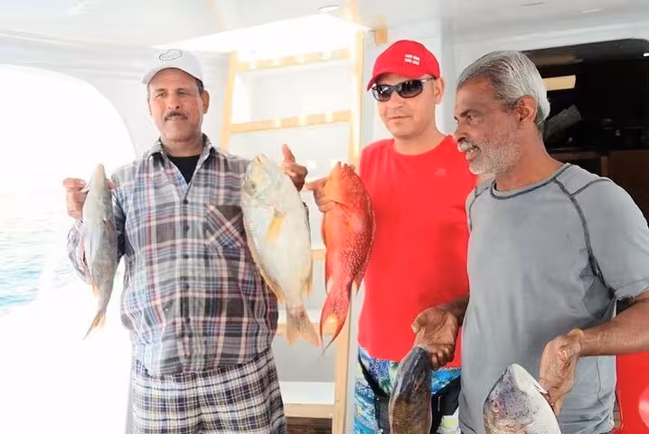 Group showing fresh Red Sea catch on boat, guided fishing tour from Hurghada with local crew and gear