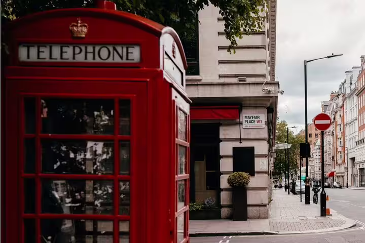 Red telephone box on Mayfair Place street corner in London's W1 district