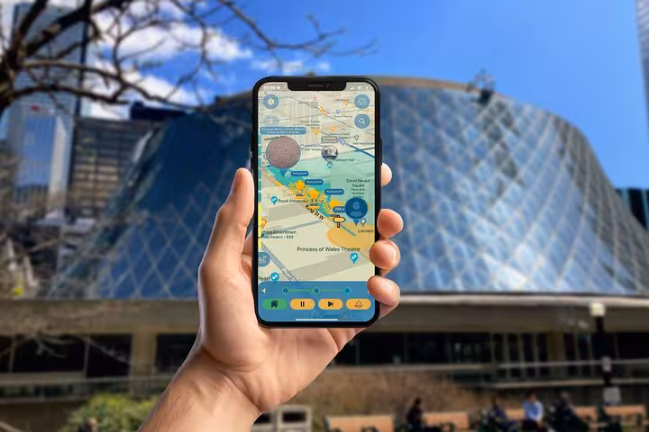 Hand holding smartphone with Reel Toronto GPS tour app showing Princess of Wales Theatre area map in downtown Toronto