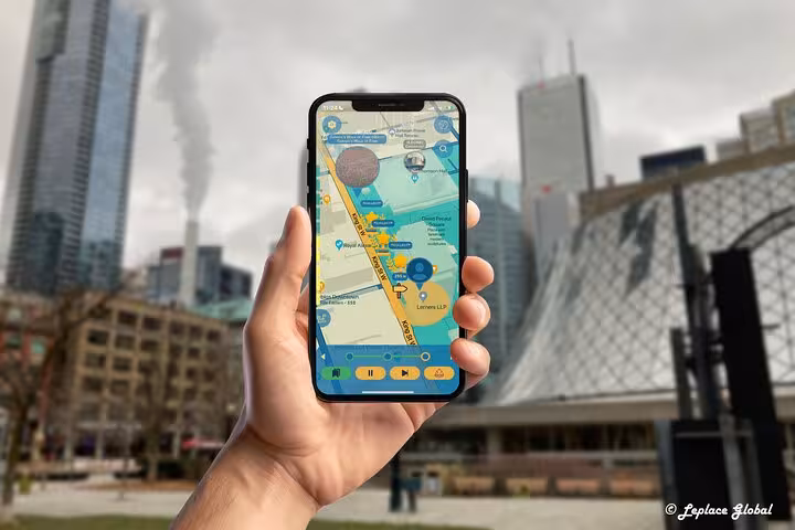 Hand holding smartphone displaying Reel Toronto GPS walking tour app map with downtown Toronto skyline backdrop
