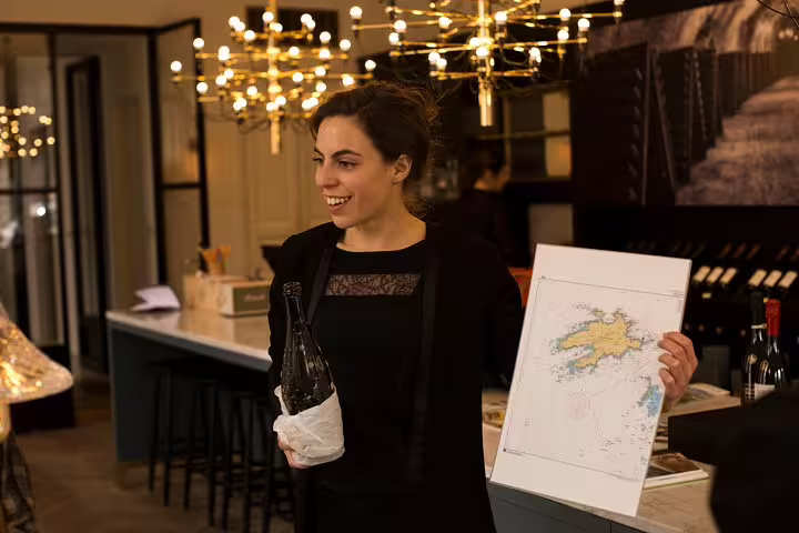 Guide presents Champagne map and bottle during Reims cellar tasting on a Champagne day trip from Paris