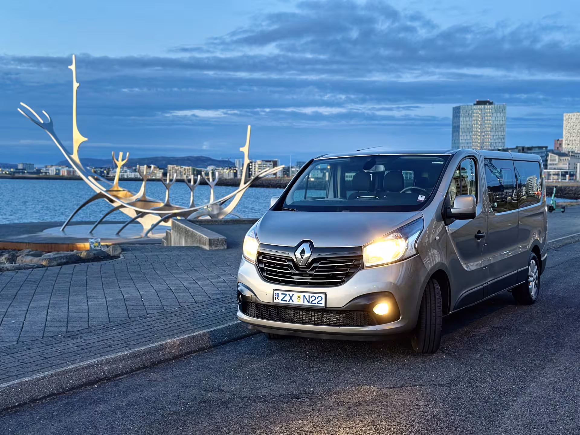 Renault Trafic minivan parked near Sun Voyager sculpture on Reykjavik waterfront at dusk
