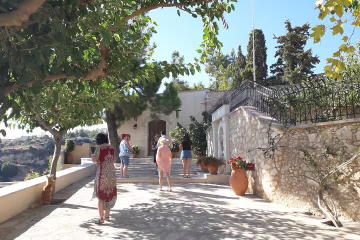 Visitors enjoy the serene landscape and architecture of St. Irini Monastery during a private tour from Chania.
