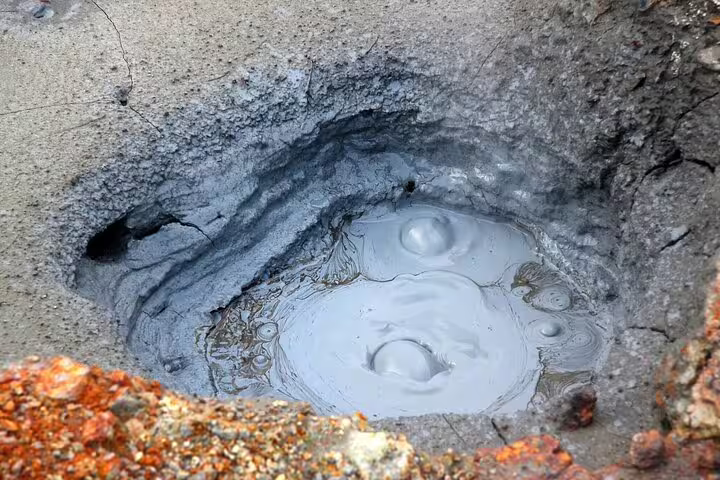 Bubbling geothermal mud pool in Reykjadalur Valley, Iceland, showcasing volcanic activity on a private hiking tour.