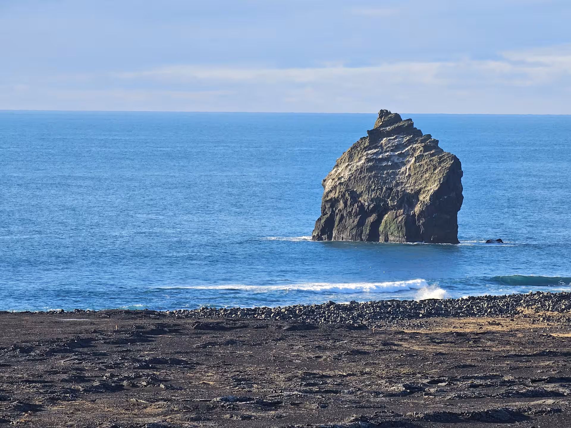 Volcanic black lava coastline with dramatic sea stack rock formation at Reykjanes Geopark, Iceland