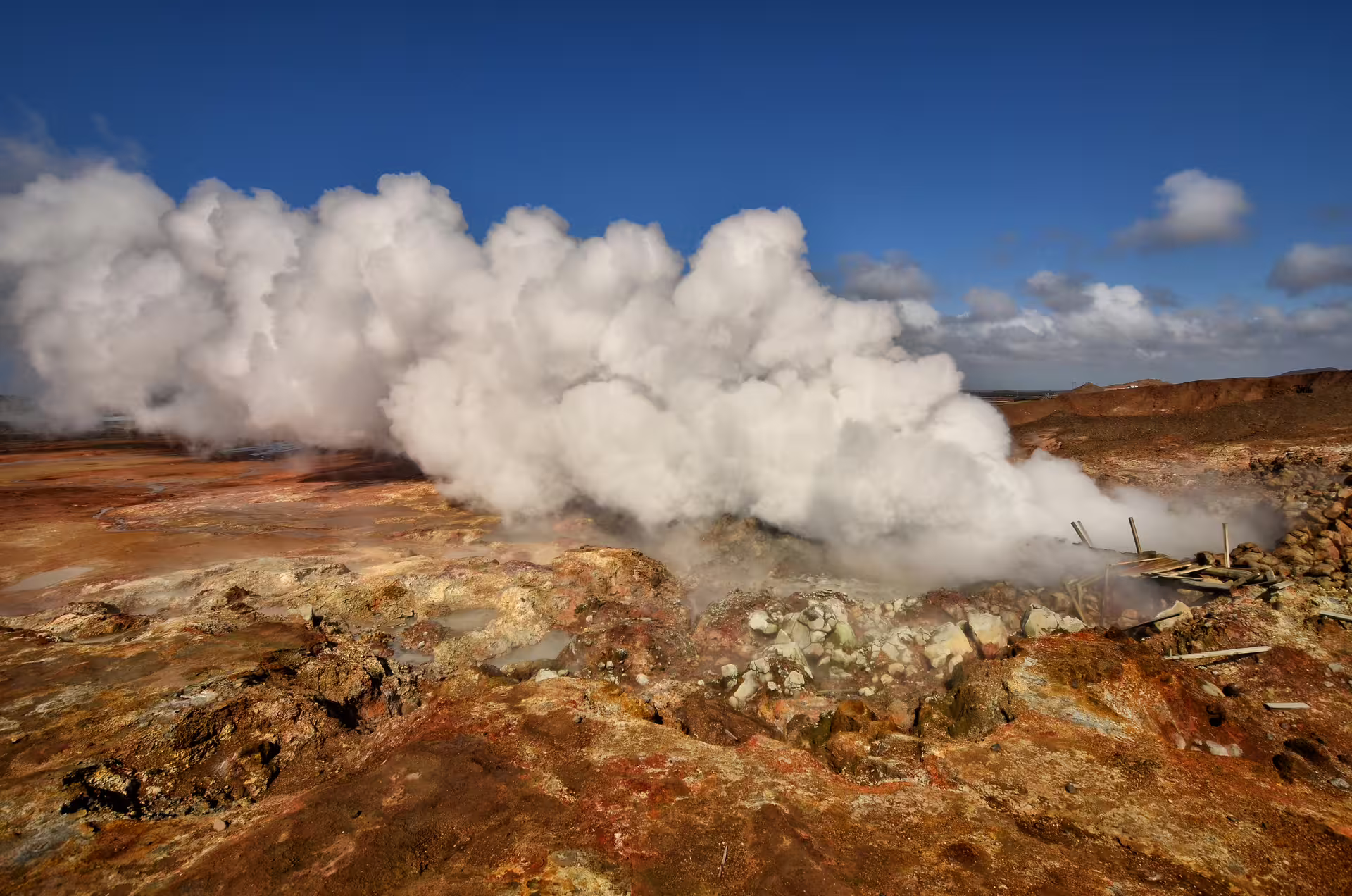 Steaming geothermal vents billowing white steam over colorful volcanic rock on the Reykjanes Peninsula, Iceland