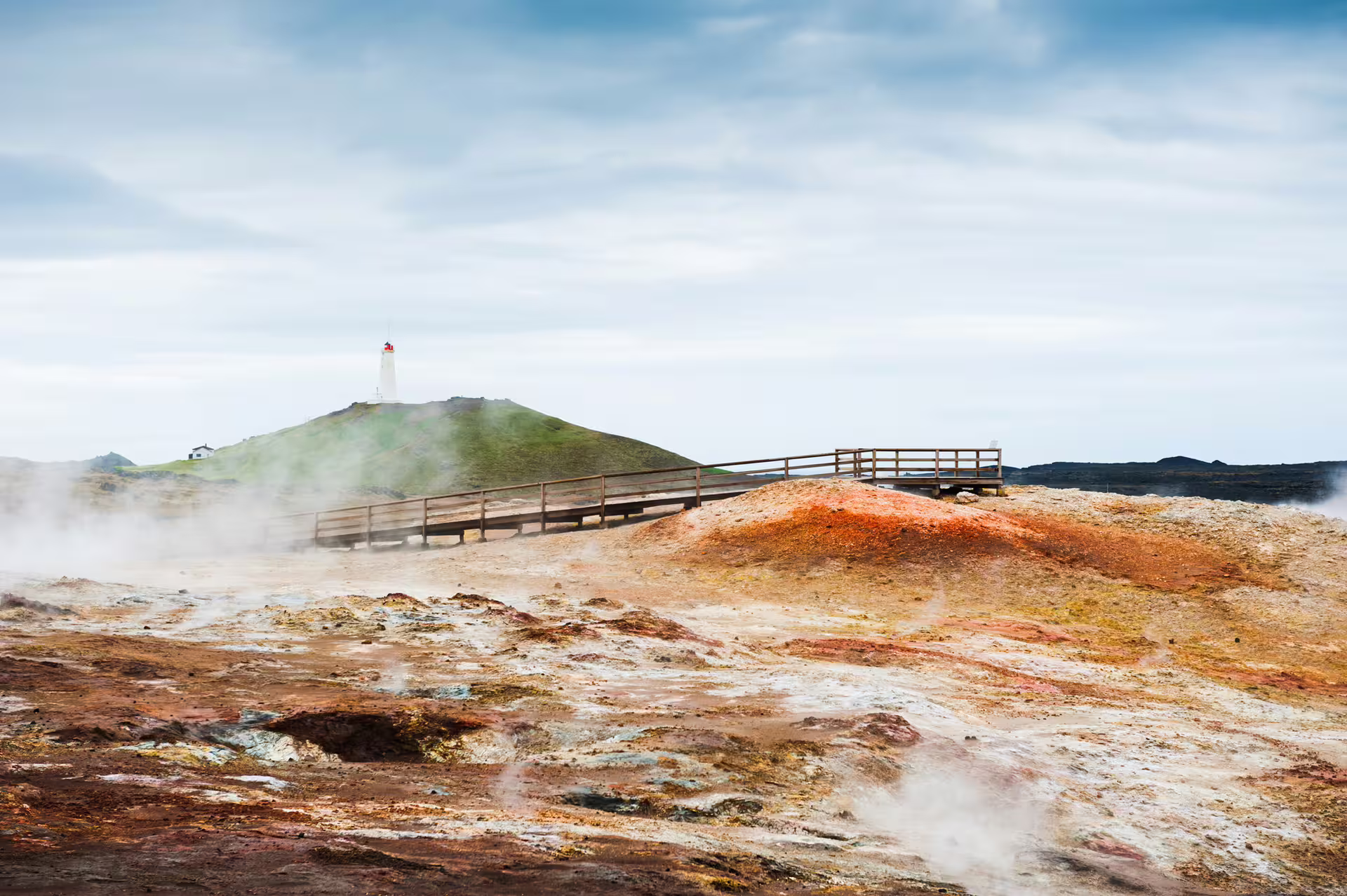 Colorful geothermal vents and boardwalk near Reykjanes Peninsula lighthouse on a private tour from Reykjavik