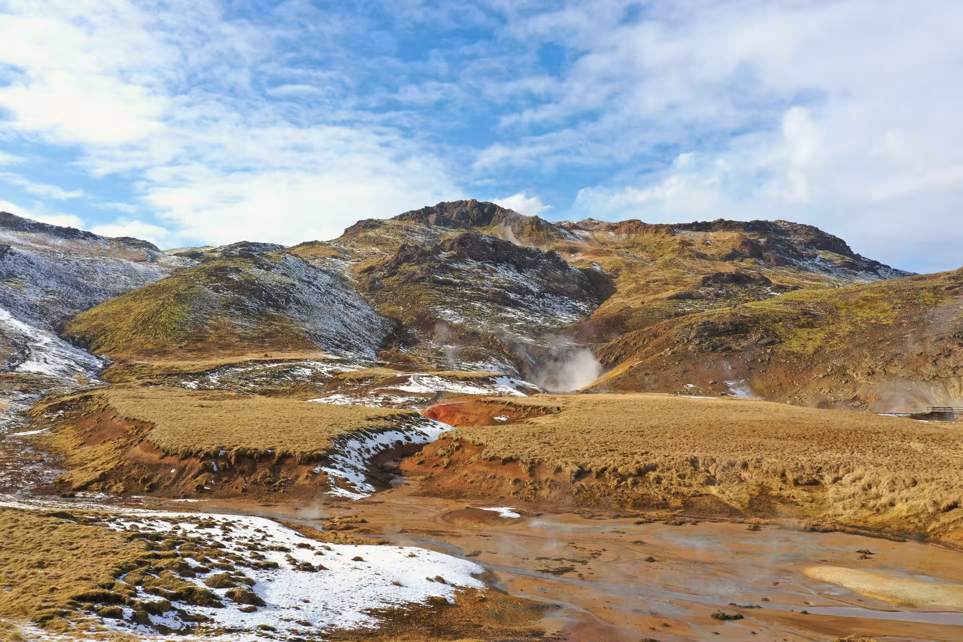 Geothermal steam vents rising over snow-dusted volcanic landscape on Reykjanes Peninsula, Iceland