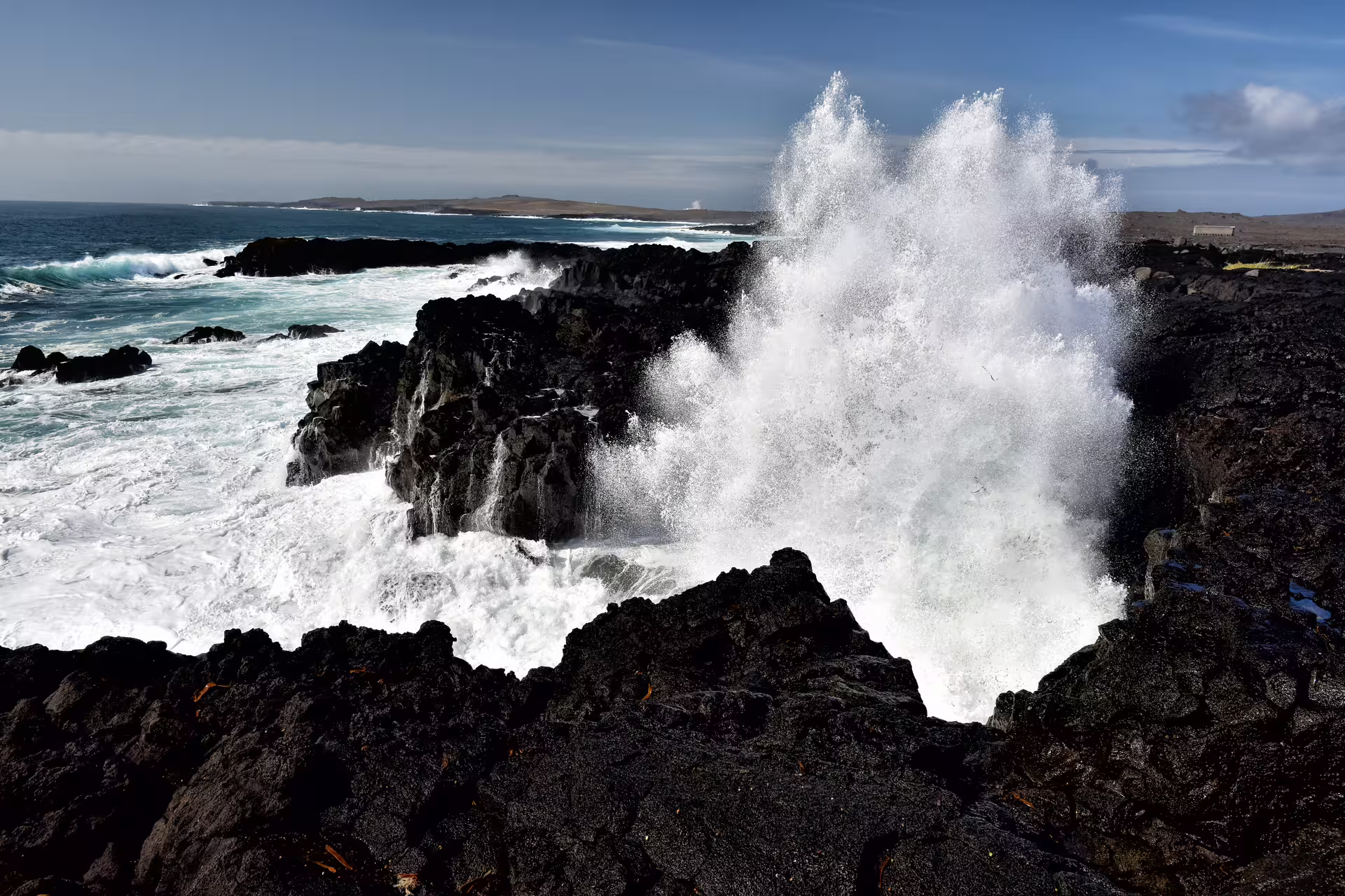 Powerful ocean waves crashing against black lava rocks on the Reykjanes Peninsula coastline