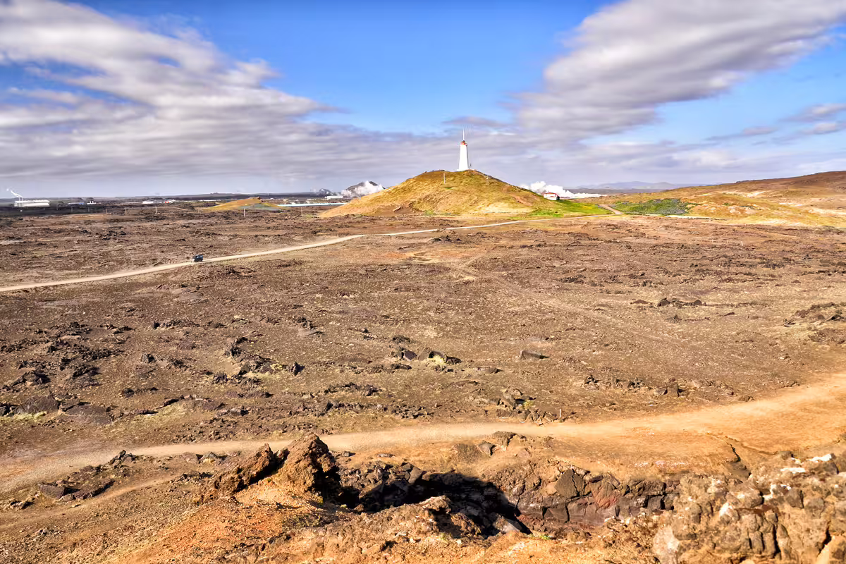 Volcanic lava fields with lighthouse on green hill, Reykjanes Peninsula Iceland
