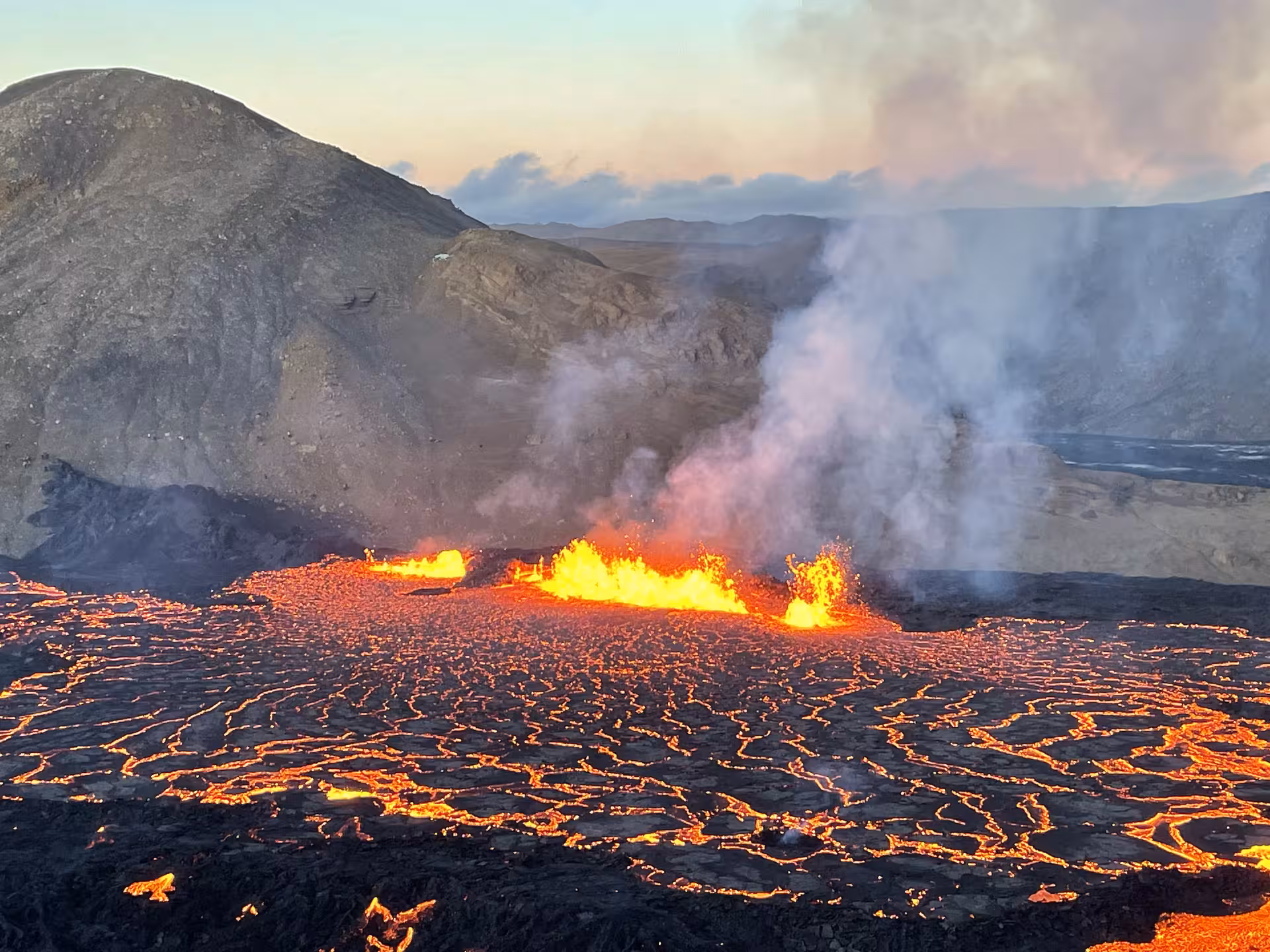 Active lava field with glowing fissure eruption and volcanic smoke on Reykjanes Peninsula, Iceland
