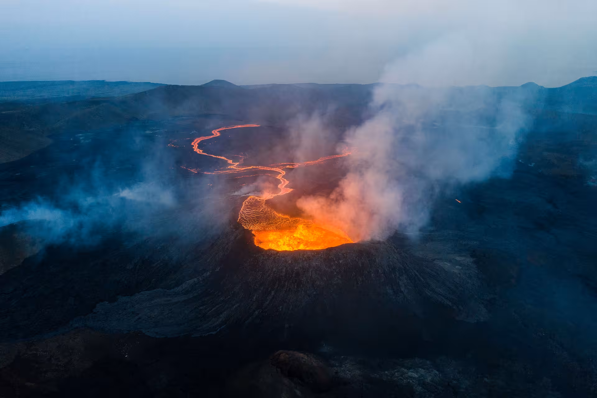 Aerial view of an active volcano with glowing lava flows and smoke on the Reykjanes Peninsula, Iceland