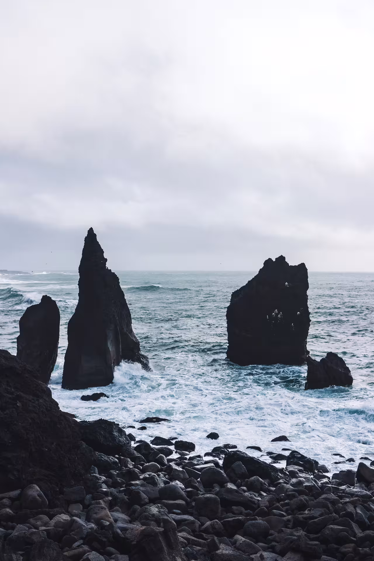 Dramatic black volcanic sea stacks rising from churning Atlantic waves on the Reykjanes Peninsula, Iceland