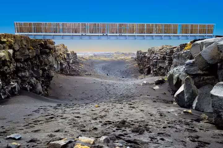 Bridge spanning volcanic rock canyon on Reykjanes Peninsula with black sand and lava fields below