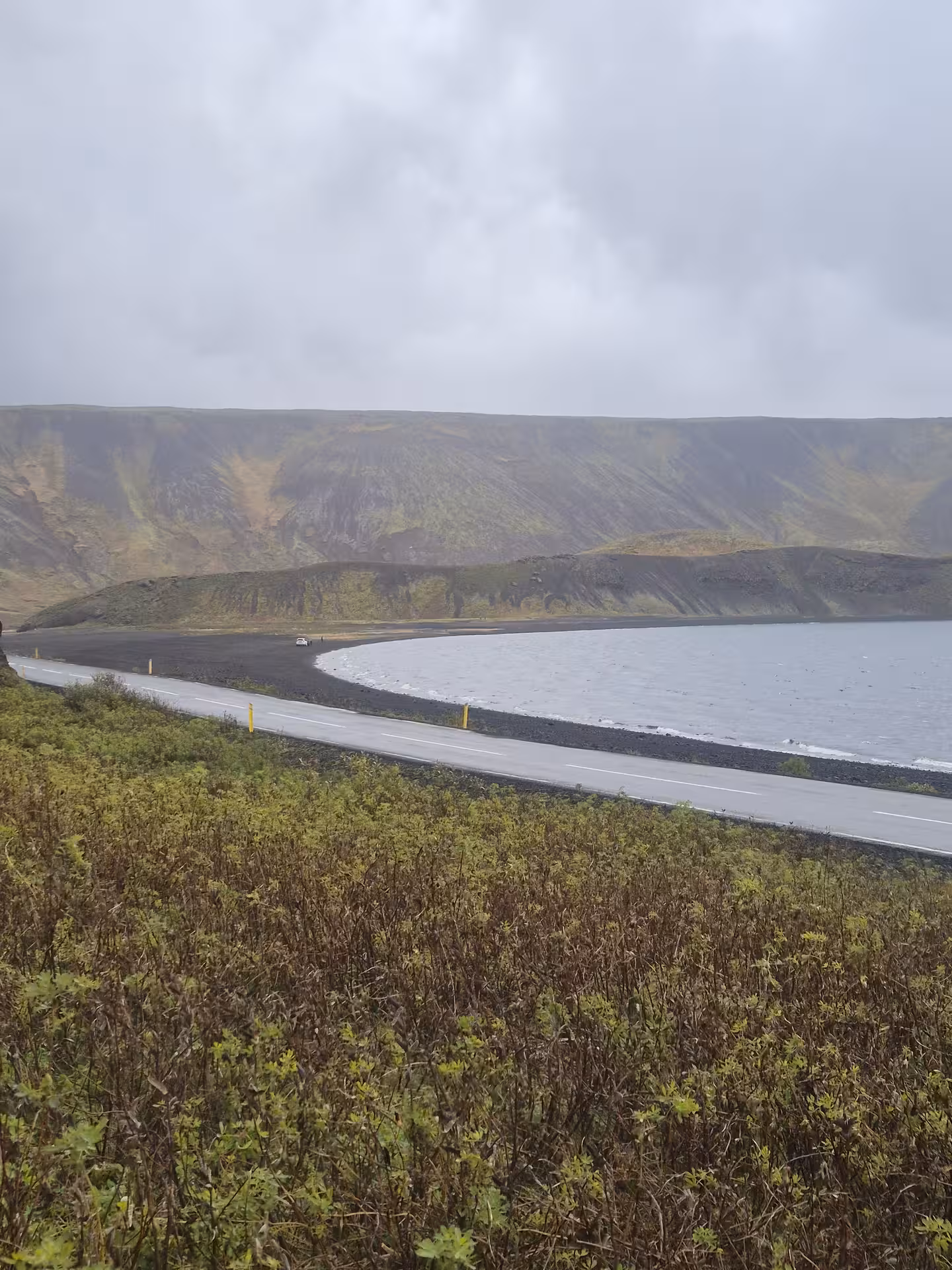 Coastal road along black sand beach with volcanic mountains on Reykjanes Peninsula, Iceland
