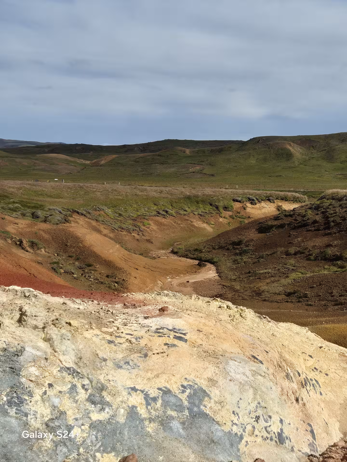 Colorful geothermal landscape with red and yellow mineral deposits on Reykjanes Peninsula, Iceland
