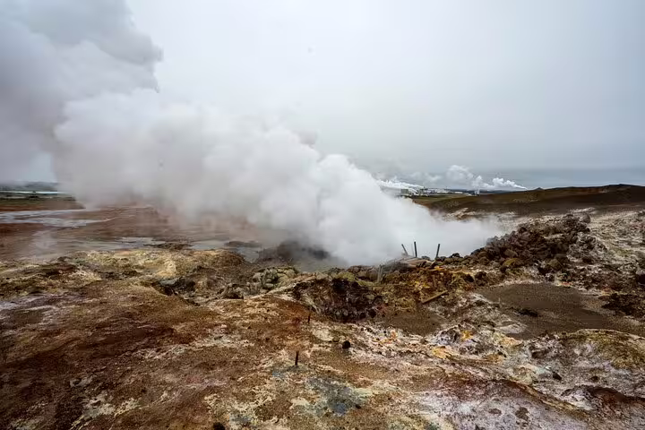 Steaming geothermal hot spring vents over colorful mineral-encrusted lava fields on Reykjanes Peninsula, Iceland