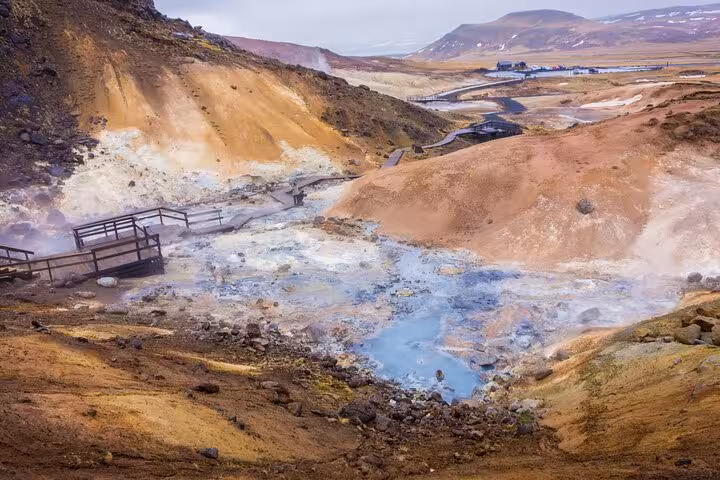 Steaming geothermal hot springs with blue mineral pools and wooden bridge on Reykjanes Peninsula, Iceland