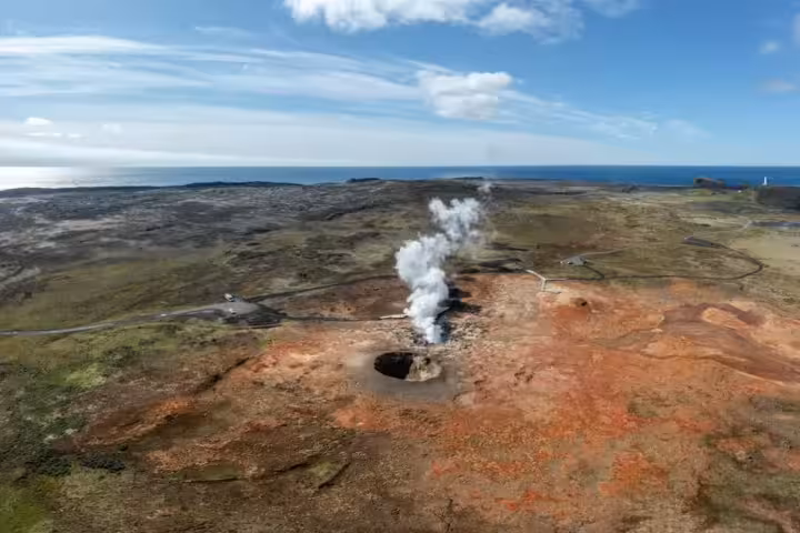 Aerial view of steaming geothermal vent on Reykjanes Peninsula with ocean horizon, Iceland