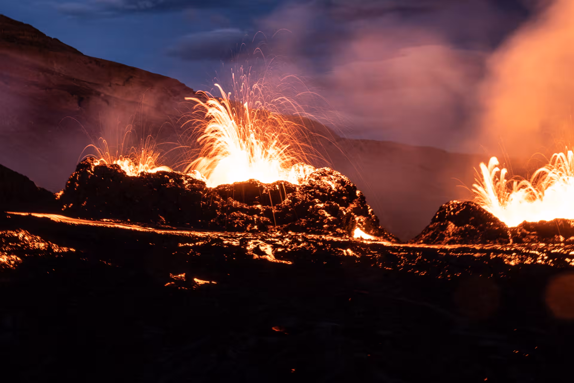 Lava fountains erupting from volcanic fissures on the Reykjanes Peninsula at night