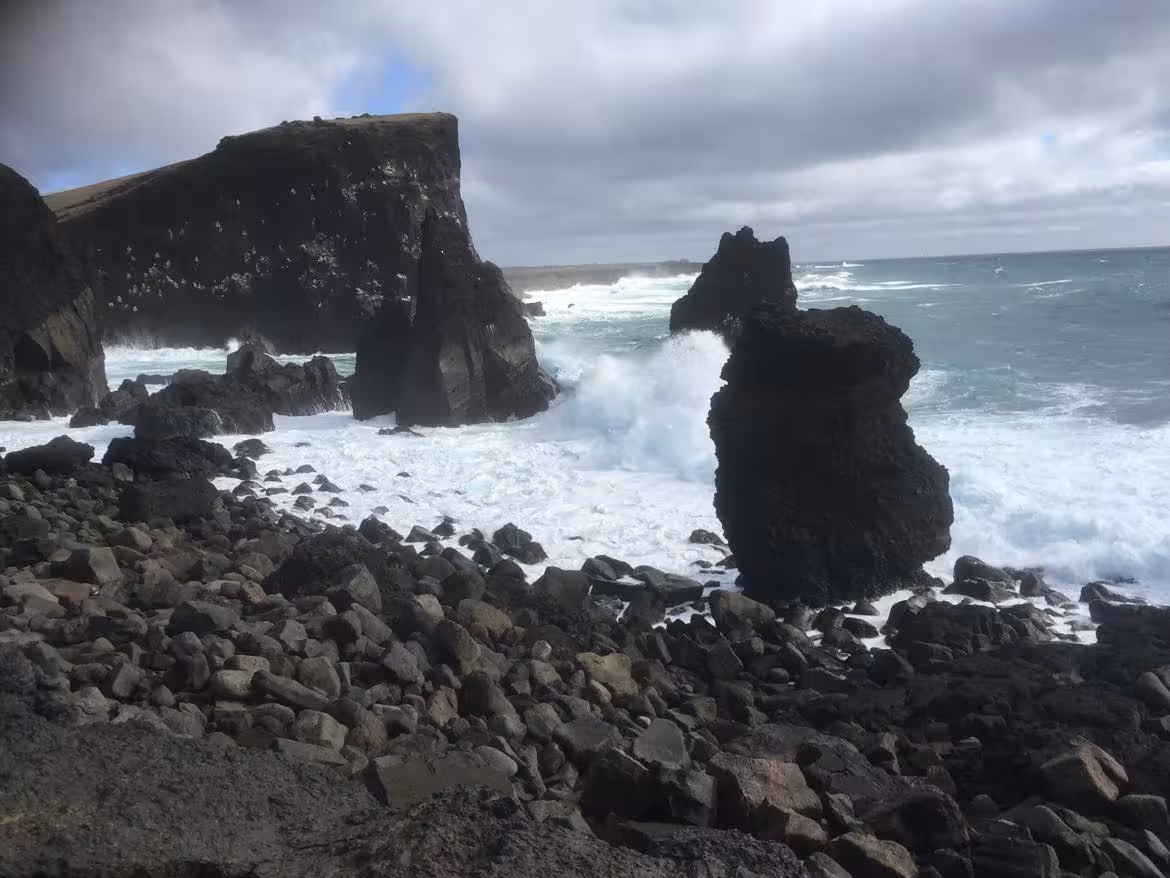 Dramatic black lava rock sea stacks with crashing waves on Reykjanes Peninsula coastline, Iceland