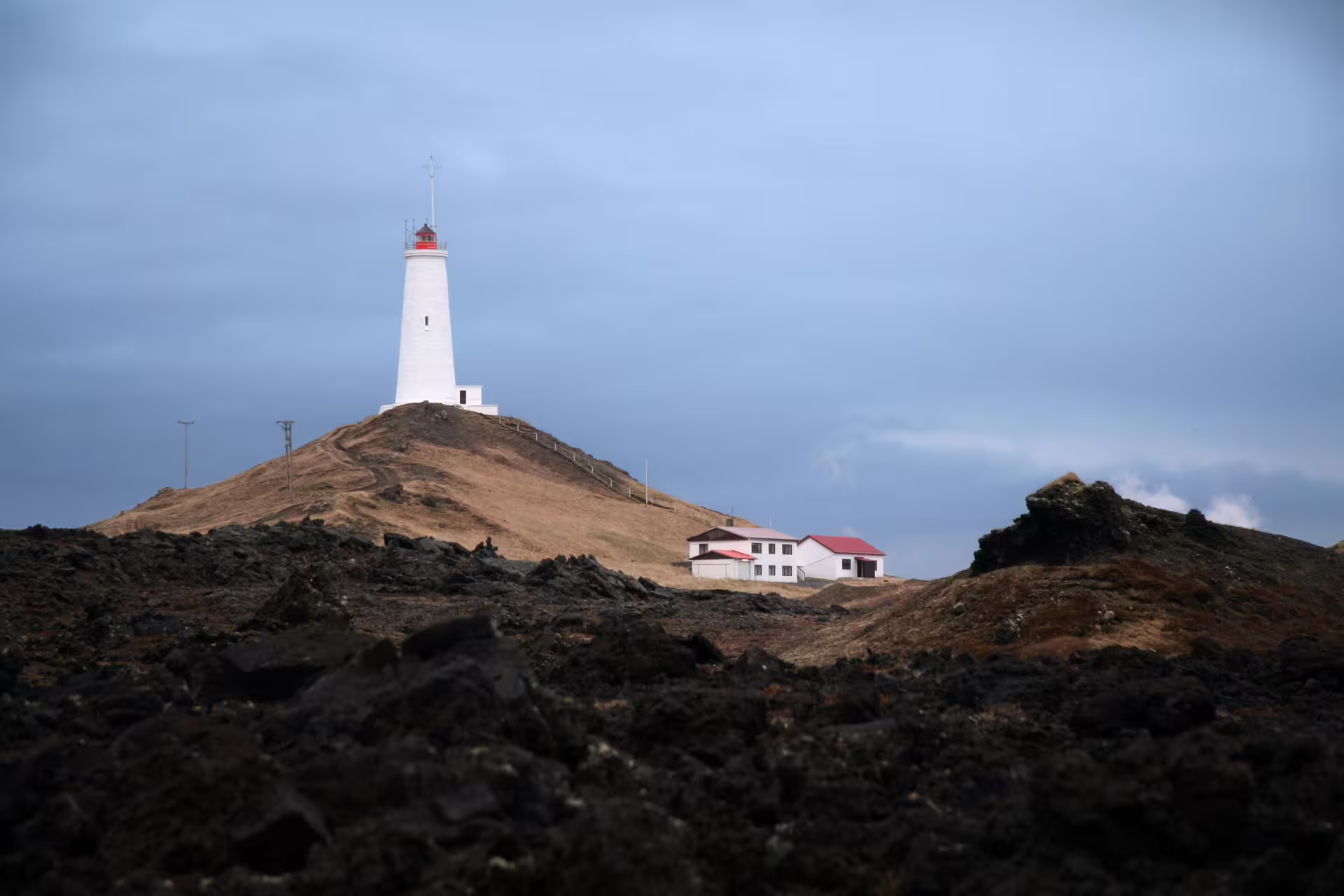 White lighthouse atop a volcanic lava hill on the Reykjanes Peninsula private tour from Reykjavik Iceland