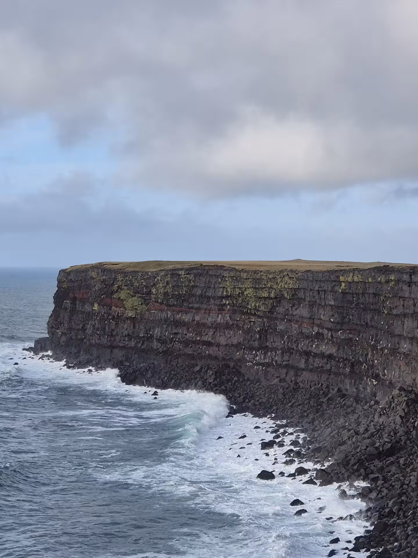 Dramatic layered sea cliffs with crashing waves on the Reykjanes Peninsula, Iceland