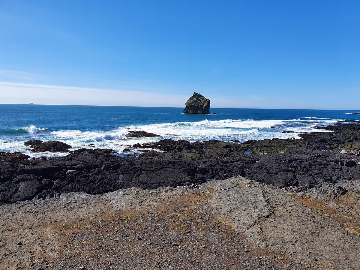 Rocky volcanic coastline with sea stack and crashing waves on the Reykjanes Peninsula, Iceland